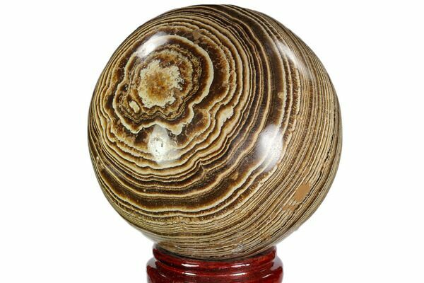 A polished sphere of banded aragonite from Morocco.  The bands are caused by layered mineral growth over time.
